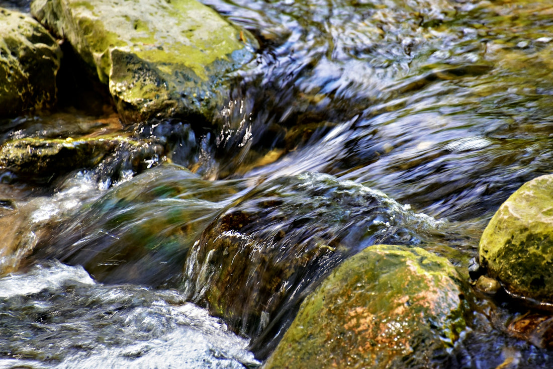 a small stream of water running over rocks
